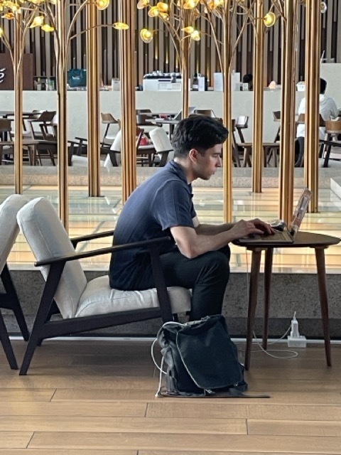 Person hunched over laptop on couch